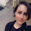 katieastrophe: selfie photo of katie in krakow, poland - wearing a black coat, black tshirt, & red trousers, & smiling (Default)